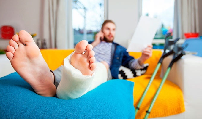 FMLA fraud man-with-leg-in-cast-sitting-by-crutches_680x402